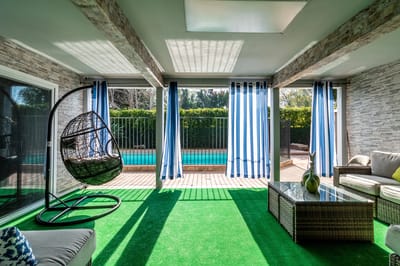 Bright lounge area with pool view and hanging chair