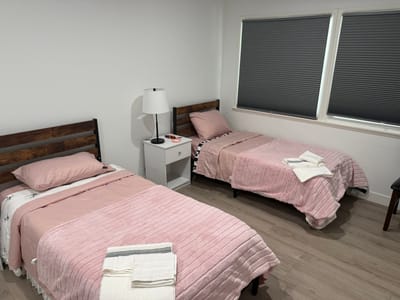 A shared bedroom with two beds and pink bedding