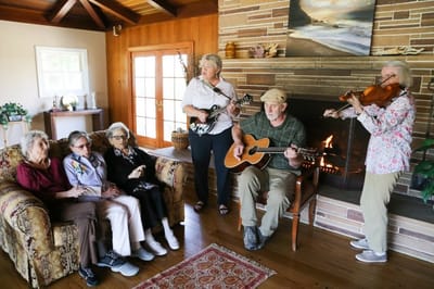 Residents enjoying live music by the fireplace