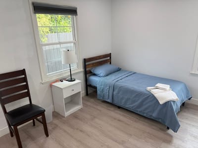 A simple interior room with a bed and chair