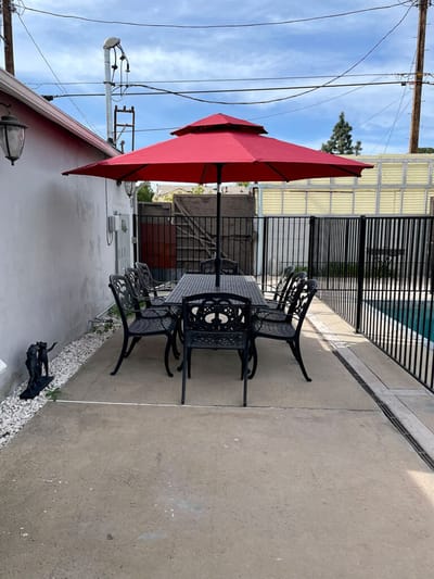 Outdoor patio seating area with a red umbrella