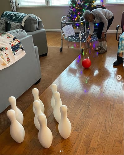 Residents participating in a bowling activity indoors