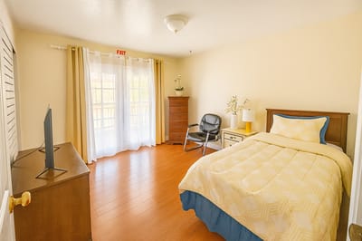Cozy private resident room with a bed and TV