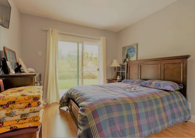 A cozy bedroom with natural light and view outside
