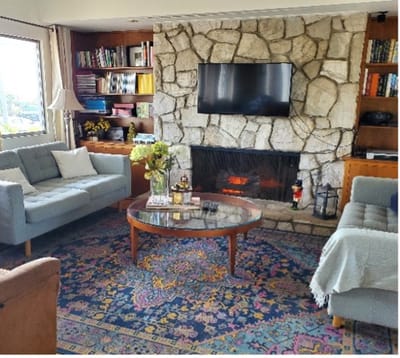 A cozy common area with a stone fireplace and seating