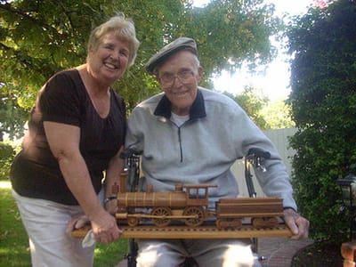 Residents enjoying outdoor activities with a wooden train model