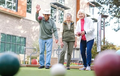 Residents playing lawn bowling in an outdoor area