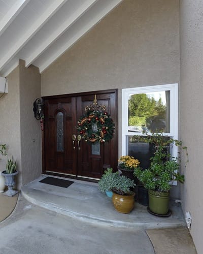Entrance with holiday wreath and potted plants