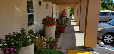 Resident standing in a colorful outdoor area with flowers