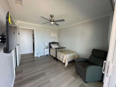 A private resident room with a bed and seating area