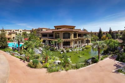 Exterior view of a landscaped facility with pond