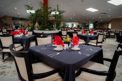 Dining room with neatly set tables and red napkins