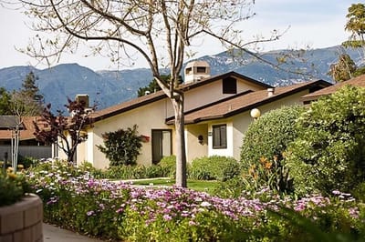 Exterior of a senior living facility surrounded by flowers