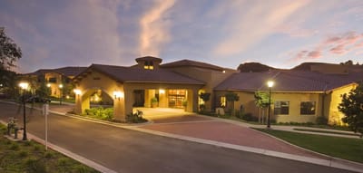 Exterior view of a senior living facility at sunset