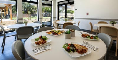 Dining area with plated meals and outdoor views