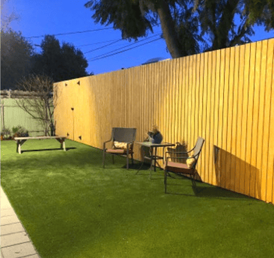 Outdoor seating area with grass and wooden fence