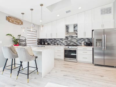 Modern kitchen interior with white cabinets and gray tiles