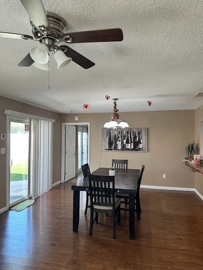 Bright dining area with a large table and ceiling fan