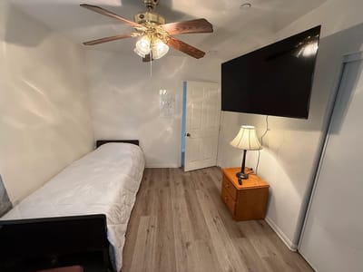 A simple, well-lit resident bedroom with amenities