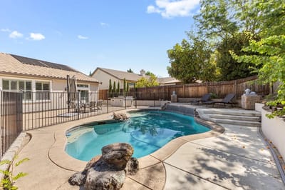 Outdoor pool area surrounded by greenery