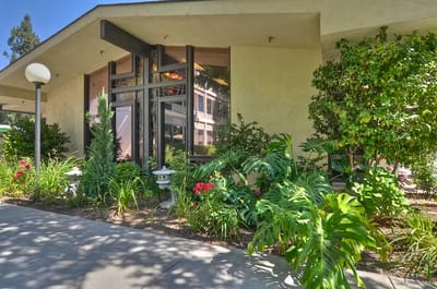 Exterior view of a nursing home entrance with gardens