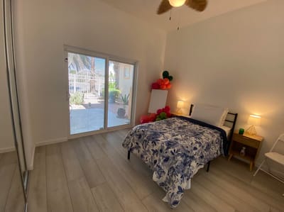 A cozy resident room with a bed and patio access