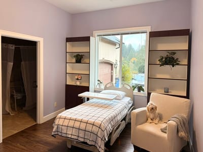 A cozy resident room with a small dog sitting on the chair