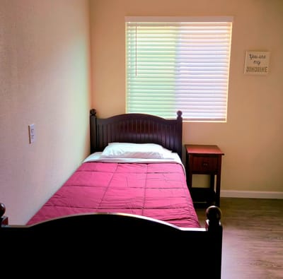 Cozy private room with a bed and side table