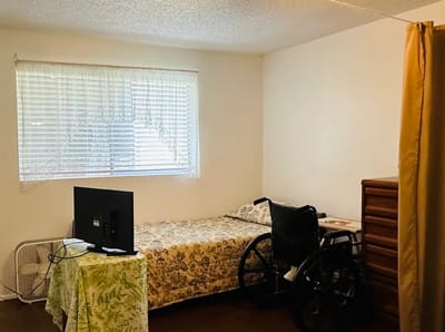 Private resident room with a bed and wheelchair