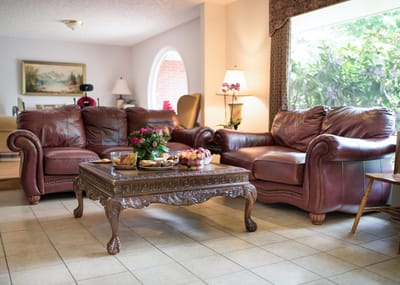 Comfortable common area with leather sofas and floral decor
