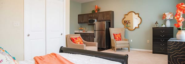 A close-up of a Meadow Brook Senior Living studio, showing the bed, closet, livi