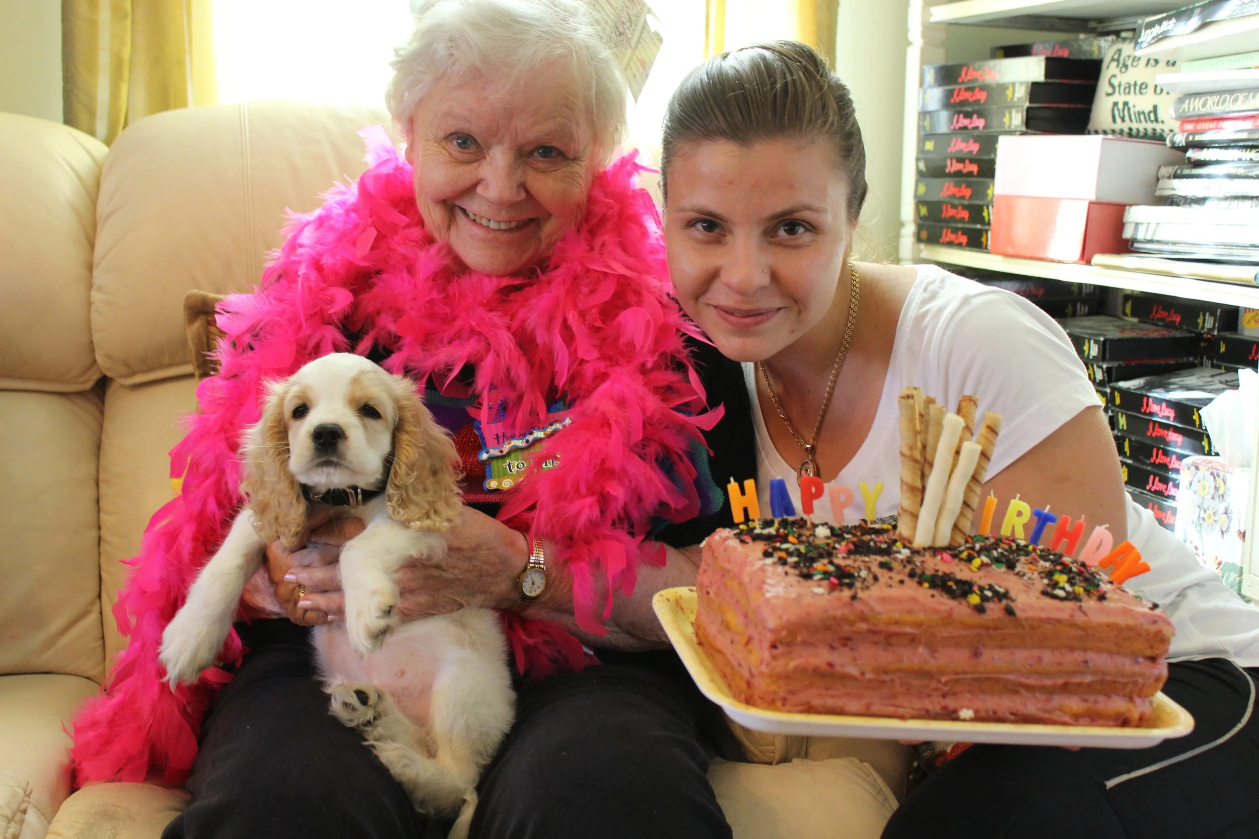 Senior celebrating birthday with a dog and cake.