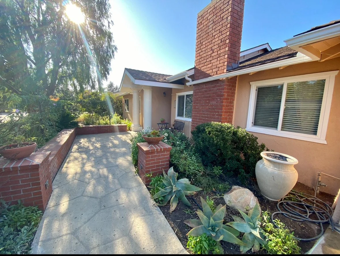 Charming entrance with garden and pathway.