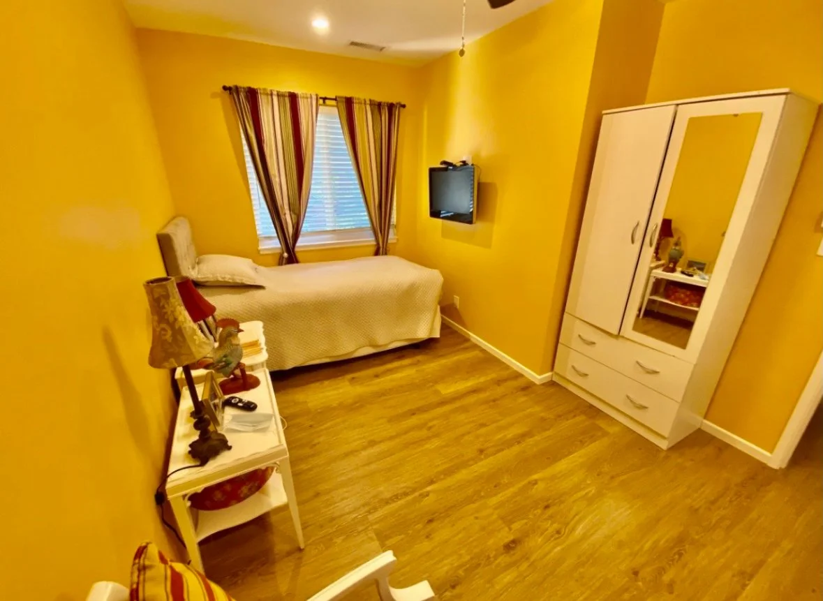 Cozy private room with yellow walls and furnishings.