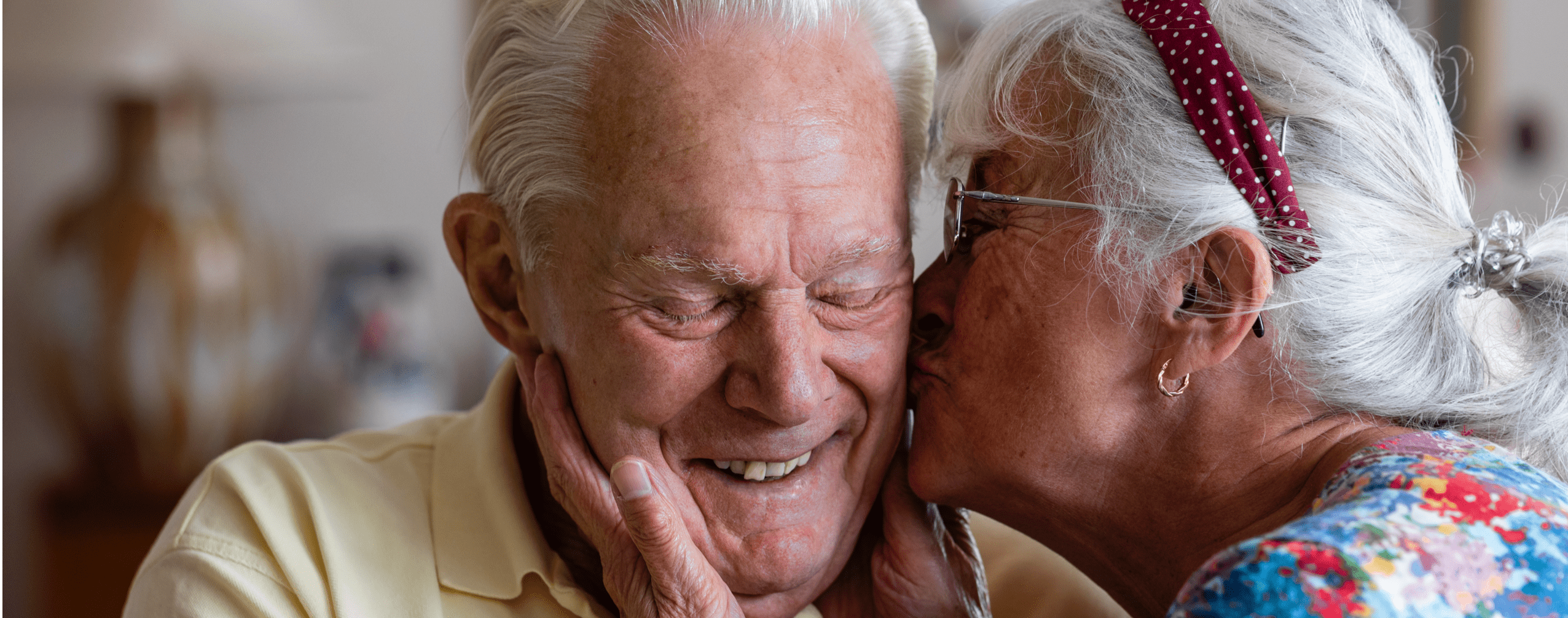 An elderly couple sharing a tender moment indoors