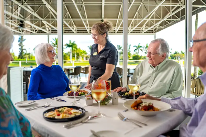 Residents enjoying a meal with staff in a dining area