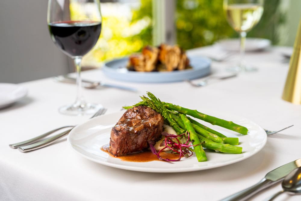 A gourmet meal with steak and asparagus on a dining table