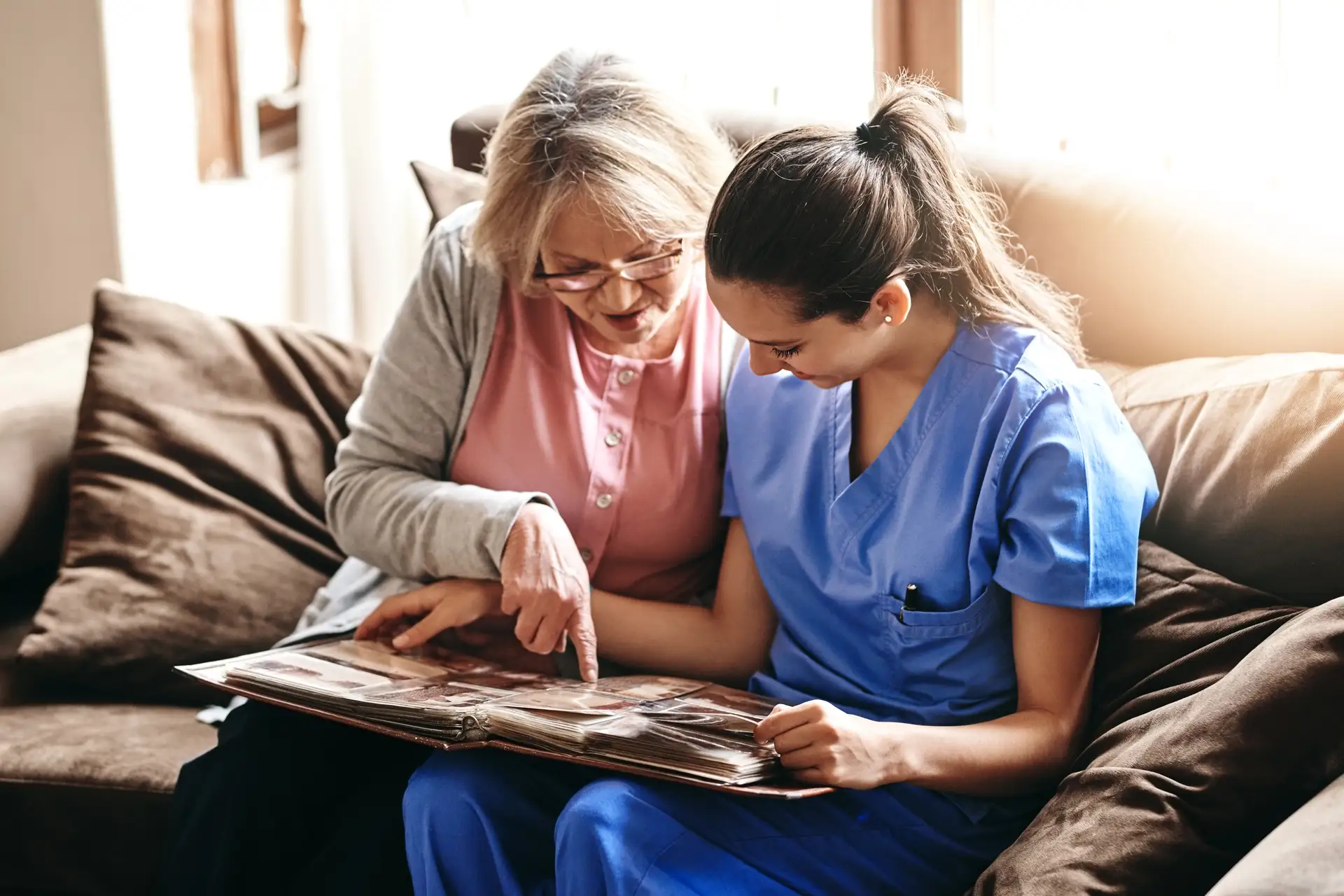 Resident and staff looking through a photo album together