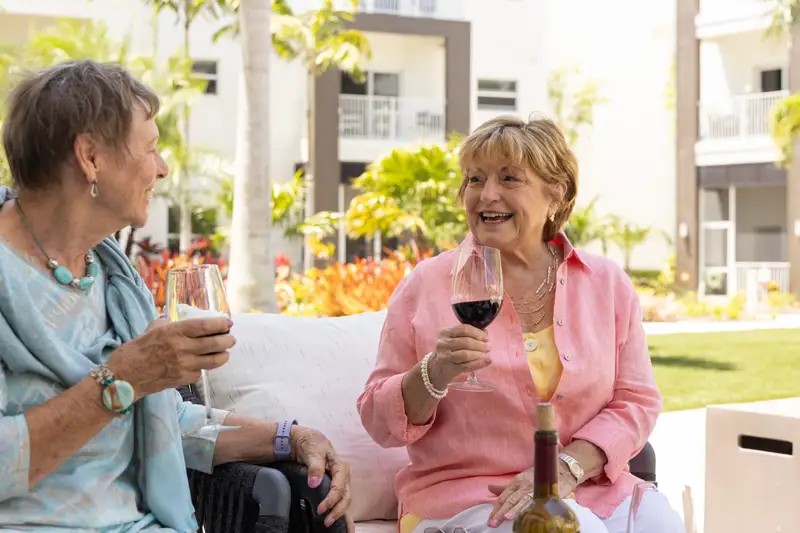 Two residents enjoying a drink in a garden setting