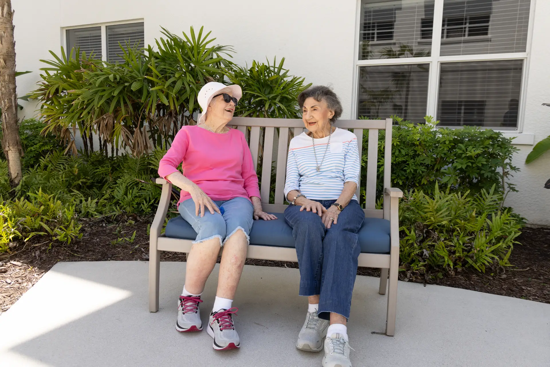 Two seniors enjoying a conversation on a bench outdoors