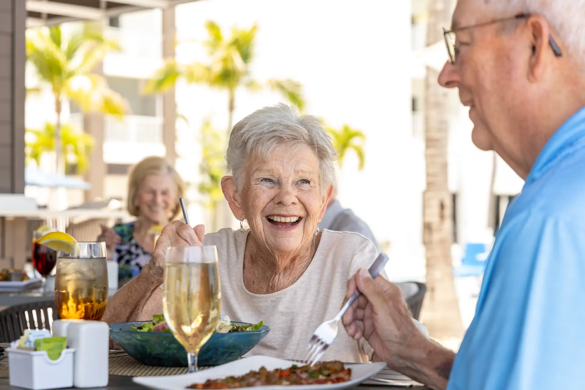 Seniors enjoying a meal outdoors at a dining area