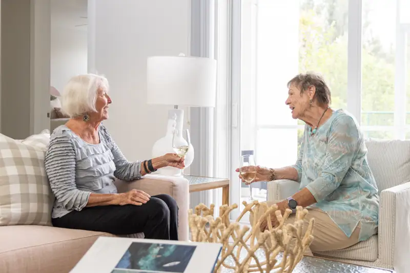 Two women enjoying drinks in a cozy common area