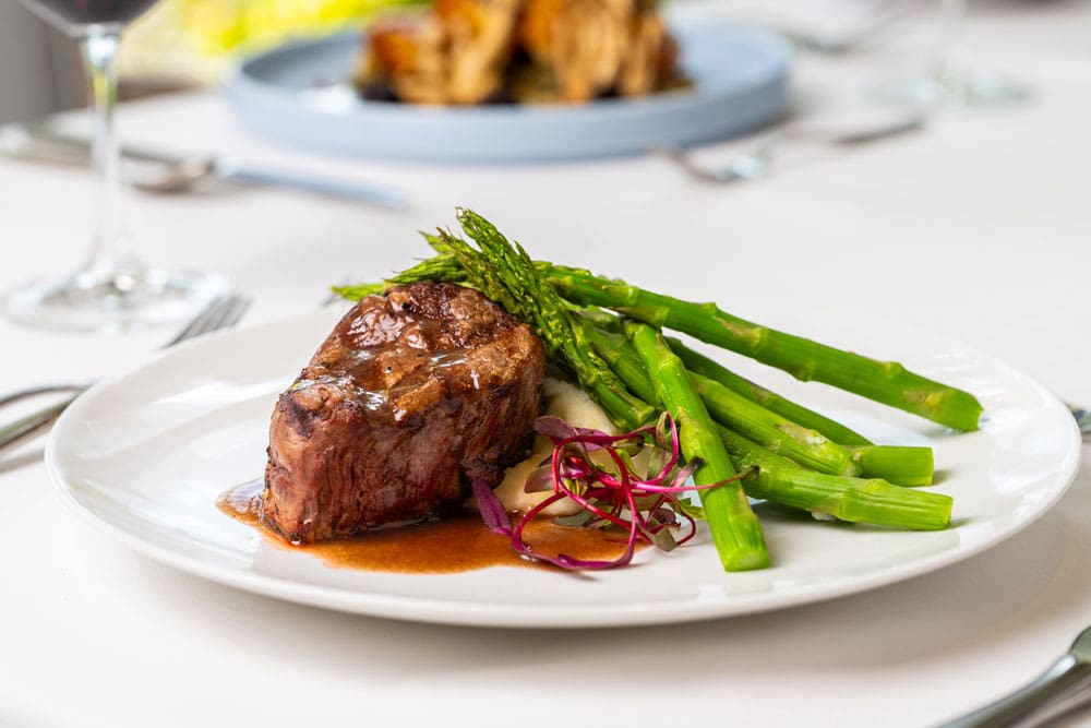 A gourmet steak dish with asparagus and garnish