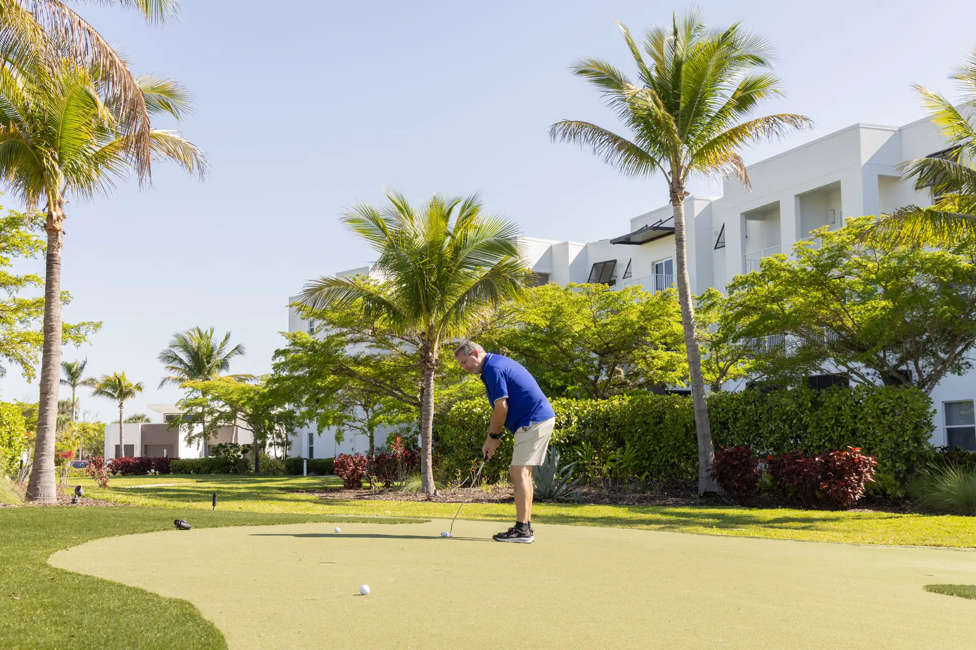 Resident playing golf in a beautifully landscaped area