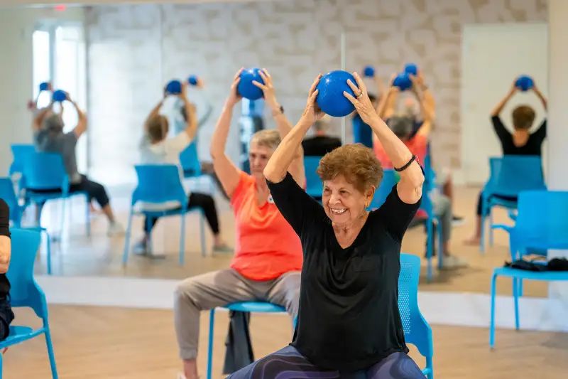 Residents participating in a fitness class using blue balls