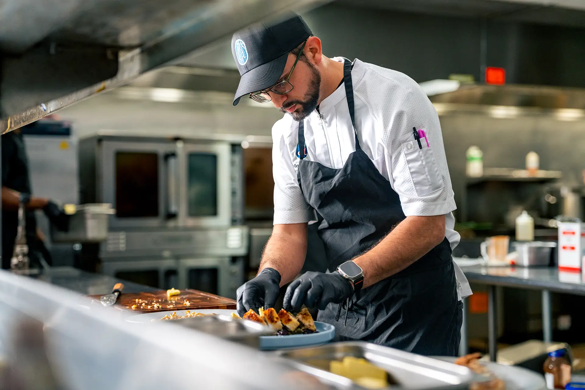Chef plating dishes in a busy kitchen