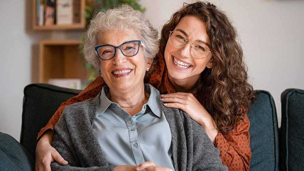 Senior woman with caregiver smiling together