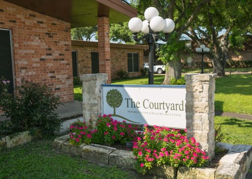 Sign and landscape of The Courtyard facility