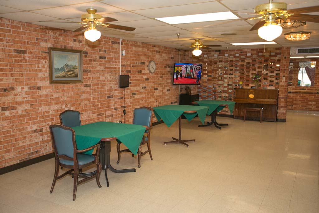 Common area with tables and a TV in the facility.