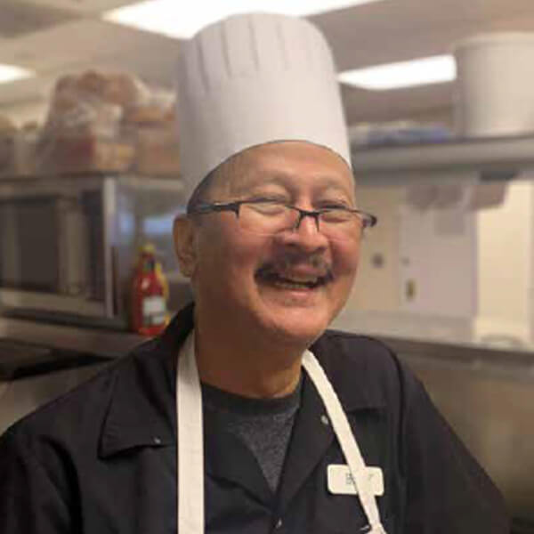 Chef smiling in a kitchen environment